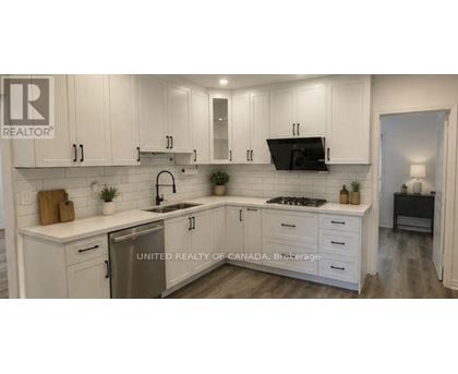 A kitchen with white cabinets and a sink.