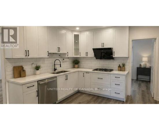 A kitchen with white cabinets and a sink.