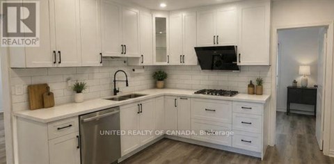 A kitchen with white cabinets and a sink.