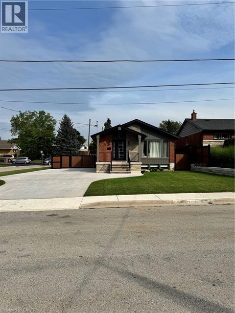 A house with a brown roof and a white fence is in the image.