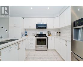 A modern kitchen with white cabinets and stainless steel appliances.