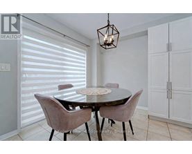 A dining room with a table and chairs.