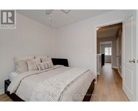 A bedroom with a bed and a doorway leading to another room.