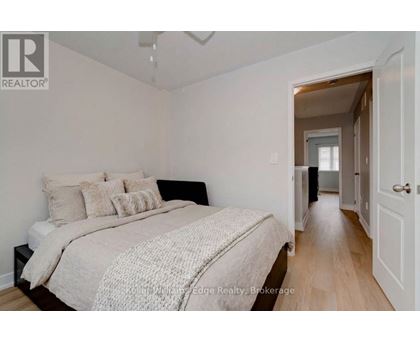 A bedroom with a bed and a doorway leading to another room.