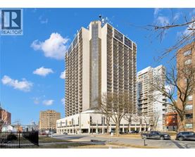 A tall building with many windows is the main focus of the image.