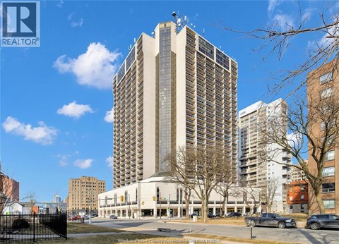 A tall building with many windows is the main focus of the image.