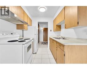 A kitchen with white appliances and wooden cabinets.