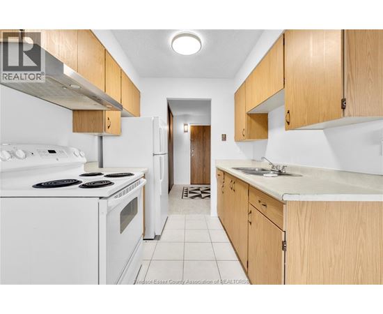 A kitchen with white appliances and wooden cabinets.