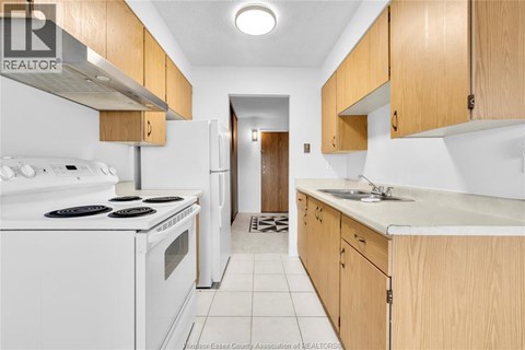 A kitchen with white appliances and wooden cabinets.