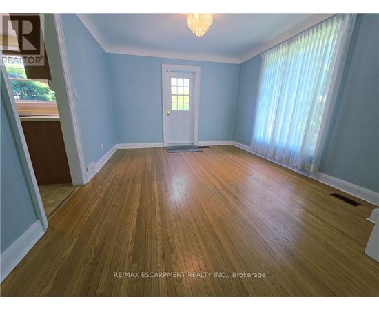 A room with wooden flooring and a white door.