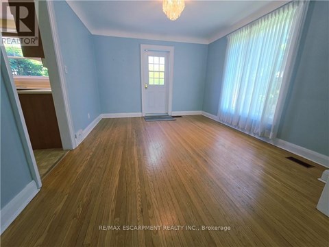 A room with wooden flooring and a white door.