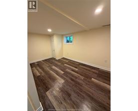 A room with wooden flooring and a window.