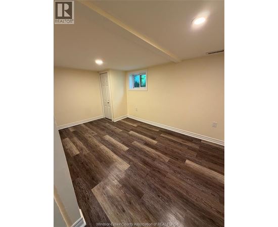 A room with wooden flooring and a window.