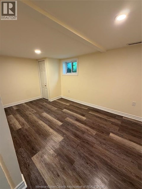 A room with wooden flooring and a window.