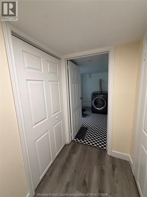 A hallway with a white door and a black and white checkered floor.