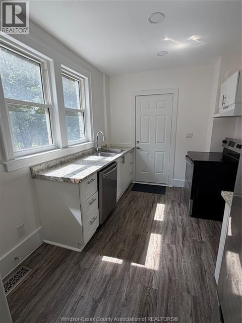 A kitchen with a sink under a window.