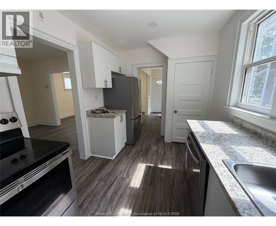 A kitchen with a stove, oven, and sink.