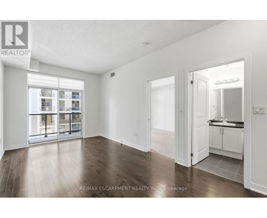 A spacious room with wooden floors and white walls.