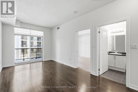 A spacious room with wooden floors and white walls.