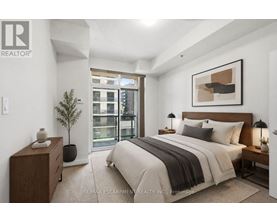 A bedroom with a large bed, a nightstand, and a plant.