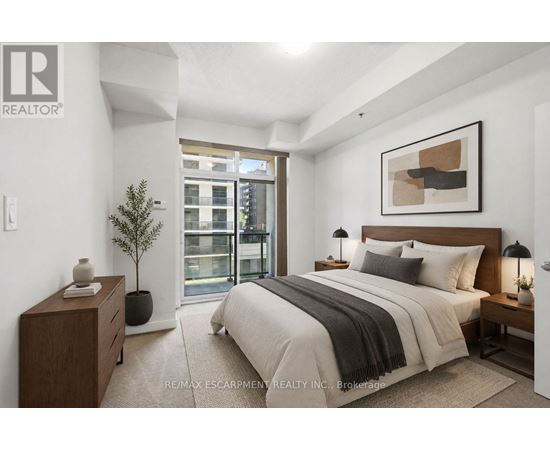 A bedroom with a large bed, a nightstand, and a plant.