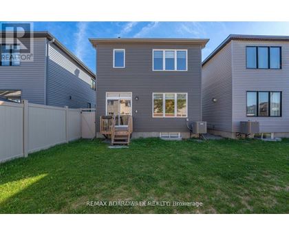 A house with a fence and a lawn in front of it.