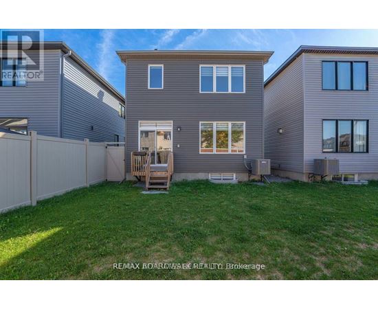 A house with a fence and a lawn in front of it.