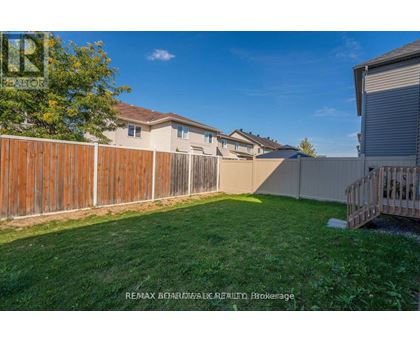 A backyard with a wooden fence and a green lawn.