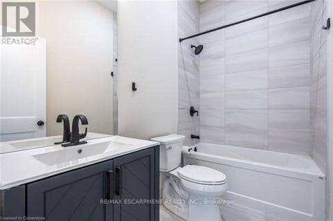 A white bathroom with a sink, toilet and bathtub.