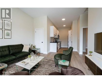A living room with a green couch and a glass coffee table.