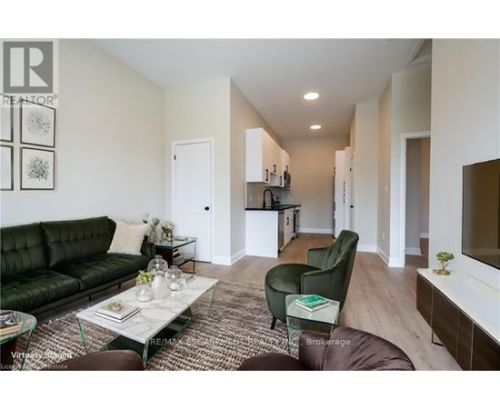 A living room with a green couch and a glass coffee table.