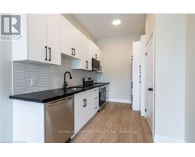 A kitchen with white cabinets and a black countertop.