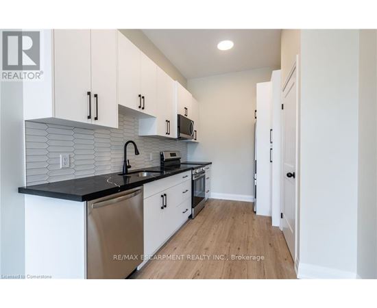 A kitchen with white cabinets and a black countertop.