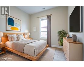 A bedroom with a bed, nightstand, and a painting on the wall.