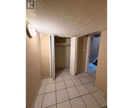 A room with a clock on the wall and a door open to another room.
