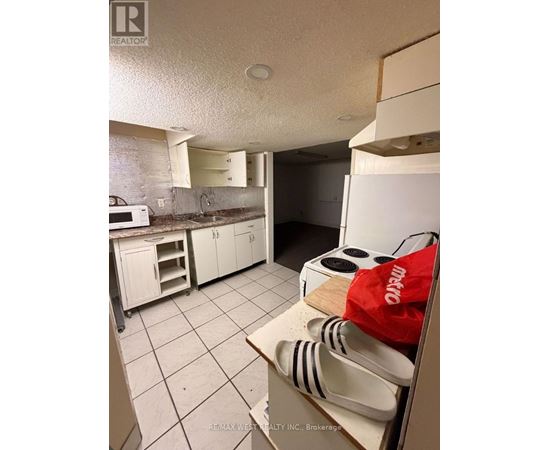 A kitchen with white cabinets and a white refrigerator.