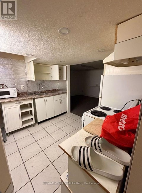 A kitchen with white cabinets and a white refrigerator.