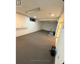 A room with a carpeted floor and a window.