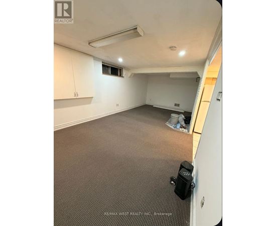 A room with a carpeted floor and a window.