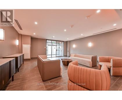 A spacious waiting area with orange chairs and a reception desk.