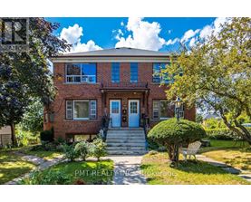 A brick house with a blue door and a small front yard.