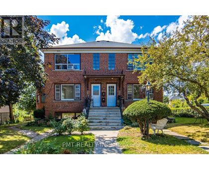 A brick house with a blue door and a small front yard.
