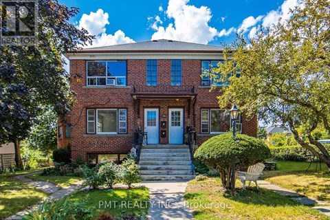 A brick house with a blue door and a small front yard.