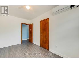A room with a wooden door and a white wall.
