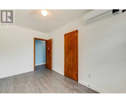 A room with a wooden door and a white wall.