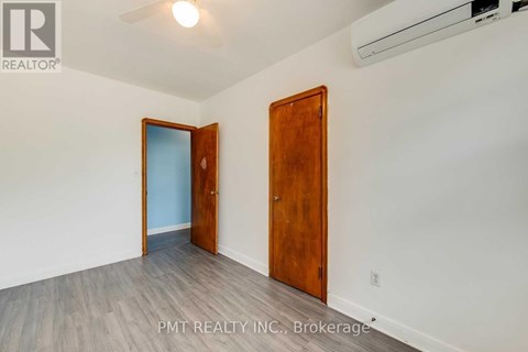 A room with a wooden door and a white wall.