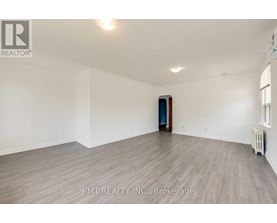 A room with a wooden floor and a door in the middle.