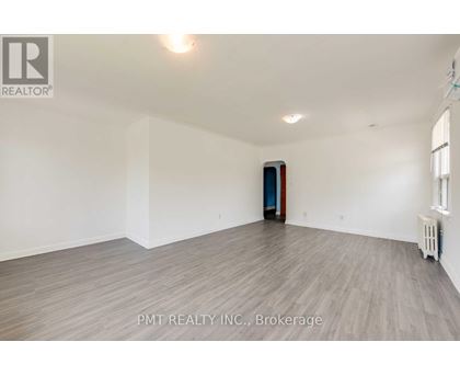 A room with a wooden floor and a door in the middle.