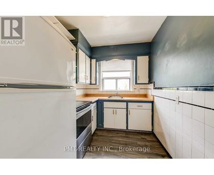 A kitchen with white cabinets and a white refrigerator.