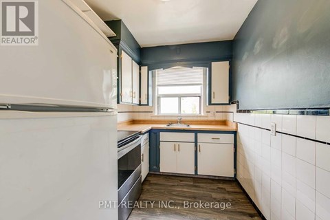 A kitchen with white cabinets and a white refrigerator.